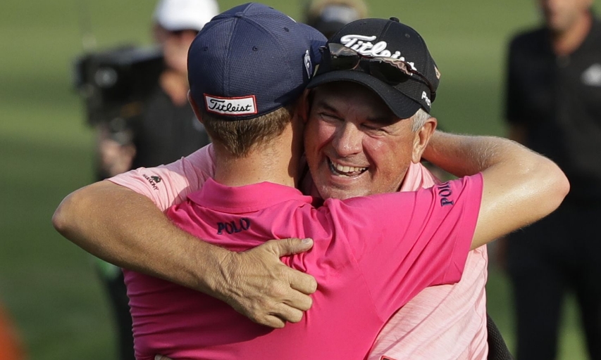 Justin Thomas hugs his father, Mike